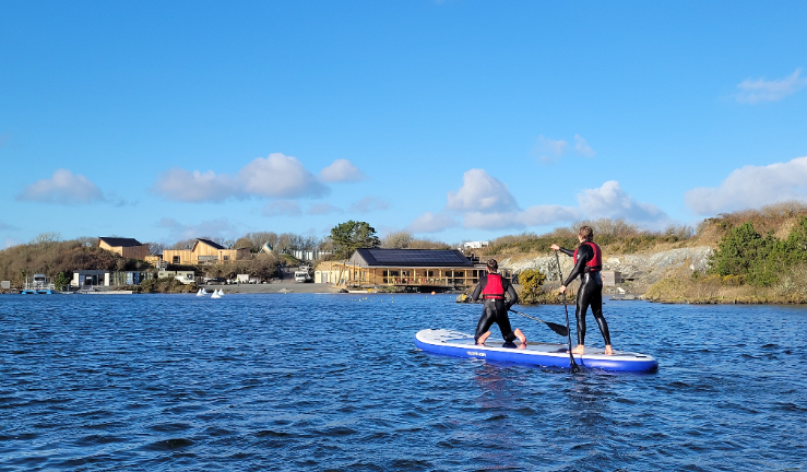 Young paddleboarders on the lake with the CST buildings in the background