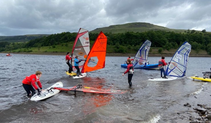 Windsurfers launching at a breezy BYS Regional Junior Champs at Glossop SC, June 2022.