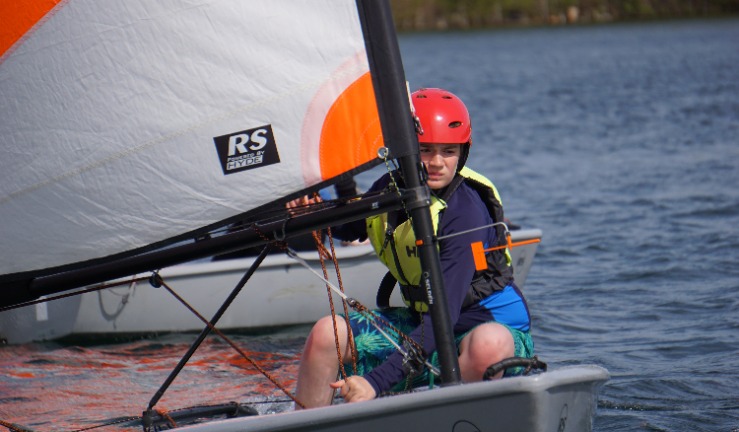 A youngster practising in a dinghy on the water