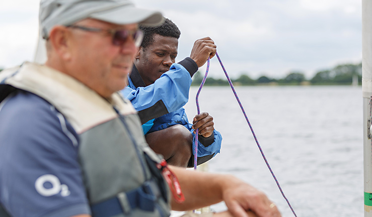 close up of a sailor and instructor using rigging