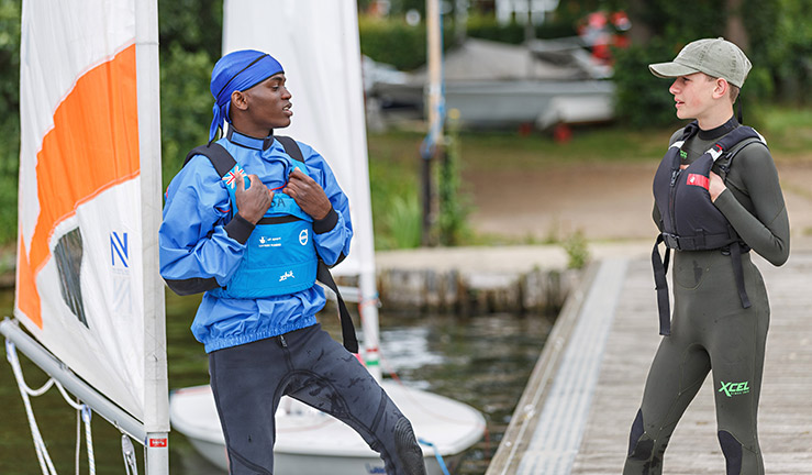 mid shot of 2 sailors talking to each other on a dock