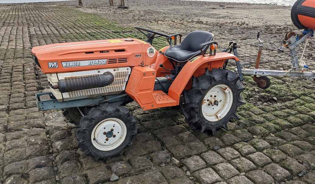 Picture of orange mini tractor attached to a Powerboat