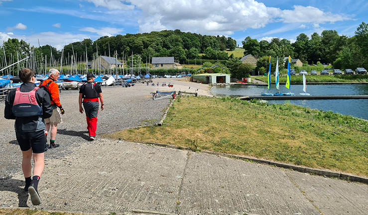 Instructors at a NE venue walking towards boats on pontoon.