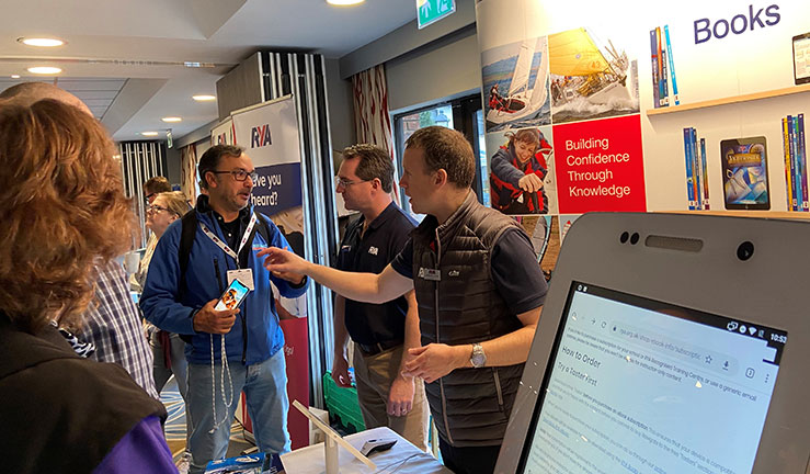 candid shot of people talking next to the book stall at the training conference