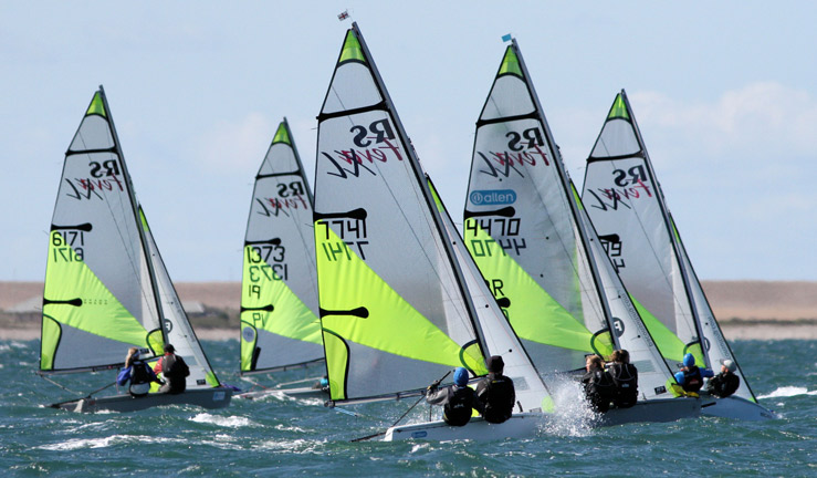 Wideshot of youths sailing in the distance