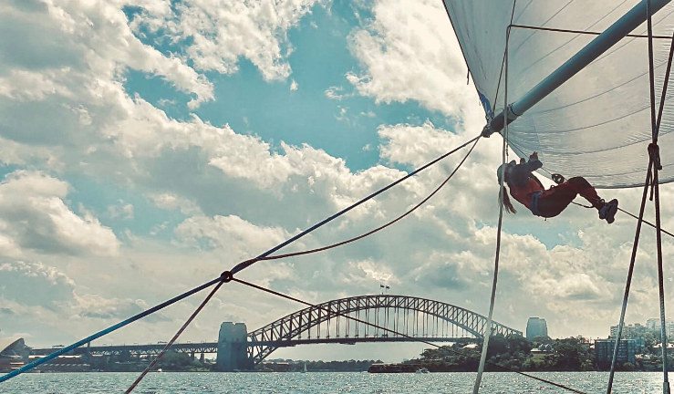 Meg high in the rigging with Sydney Harbour Bridge in the background