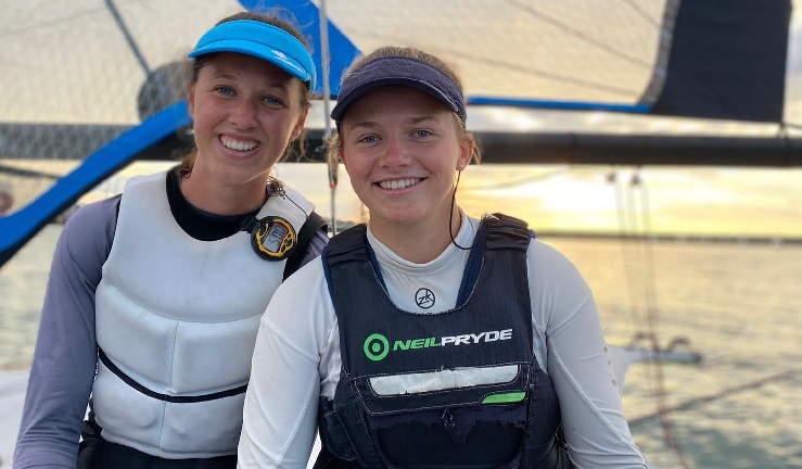 NI Sailor Erin McIlwaine ad her crew Ellie sitting on their 49er FX with a sunset in the background.