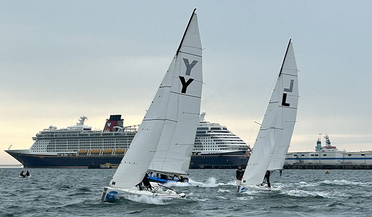 Two teams match racing Elliot 6m keelboats upwind on a grey day in Portland Harbour with a cruise ship in the background, at the 2023 RYA Marlow Ropes Women's Match Racing Championships.