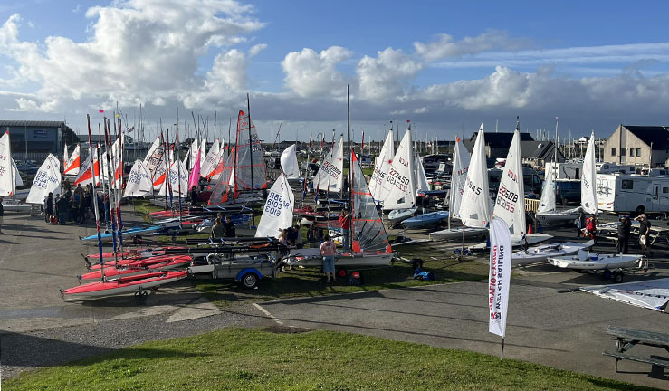 Busy boat park full of boats with sails up and sun shining at Plas Heli getting ready for the Welsh Youth & Junior Championships.