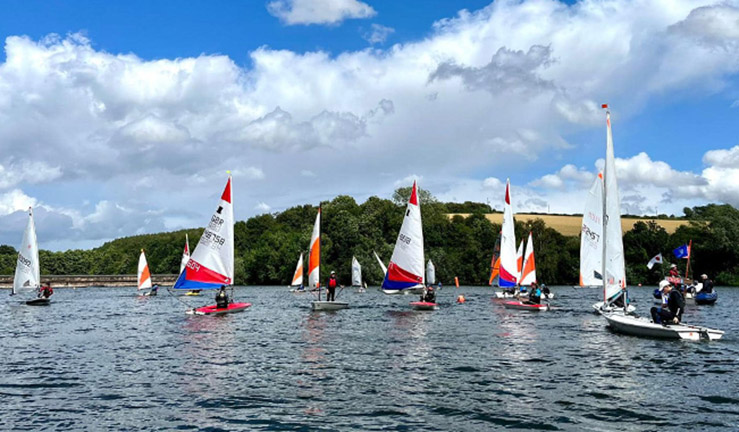 A sunny day with fluffy clouds in the sky at Ulley Sailing Club with more than a dozen colourful dinghies on the water for the North East & Yorkshire Youth Traveller Series.